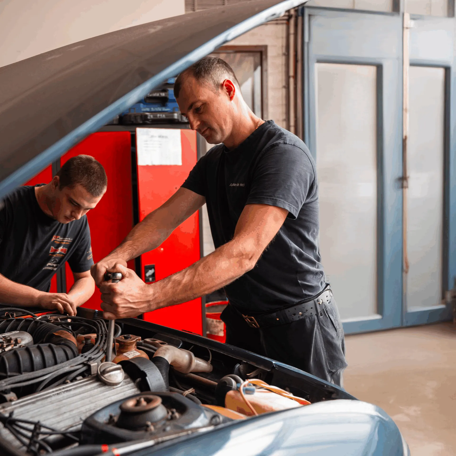 Zwei Mechaniker von Autoservice Keck arbeiten im Motorraum eines Autos