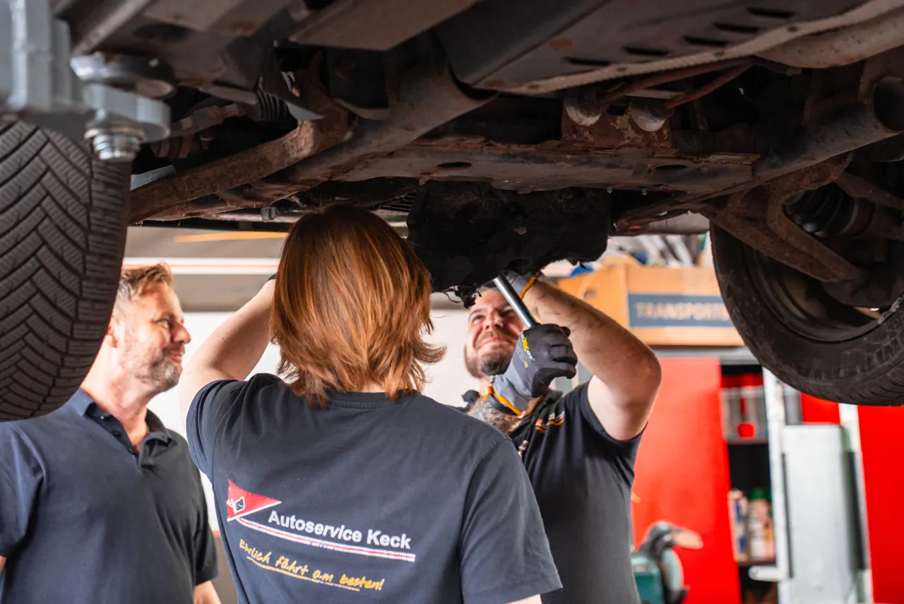 Mechaniker von Autoservice Keck arbeiten an einem Auto auf der Hebebühne